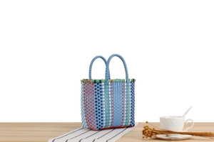 Détail d'un panier pique-nique coloré tressé à la main avec double poignée robuste