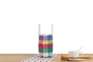 Détail d'un sac pique-nique coloré tressé à la main avec des motifs à rayures