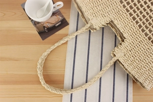 Macro detail of French style hollow paper rope woven beach bag with large mesh pattern