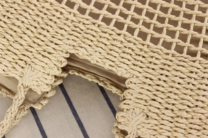 Detail of woven straw bag showing hollow diamond mesh pattern and beige fabric lining