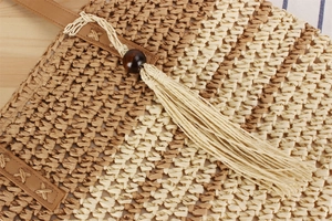 Détail d'un sac en corde de papier tissé avec gland, perle en bois et couture en cuir