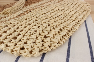 Gros plan du sac en paille tressée avec pompon long et texture tissée détaillée