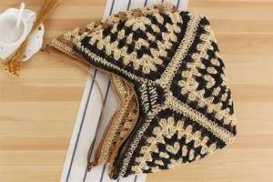 Flat lay of woven tote bag with tricolor pattern and leather straps on wooden desk