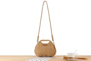 Detail of hand-woven paper straw bag featuring hollow handle and leather closure