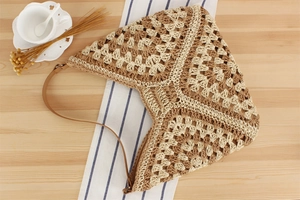 Detail of hollow woven tote bag with geometric patterns and brown leather strap