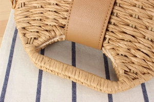 Detailed close-up of handmade paper rope woven bag with brown faux leather strap