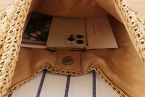 Interior detail of large woven paper straw bag with magnetic closure and brown lining