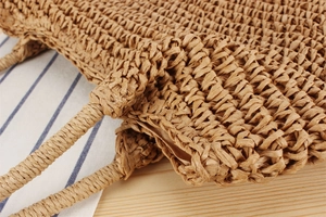 Detail of handmade woven shoulder bag showing natural paper rope texture and inner lining