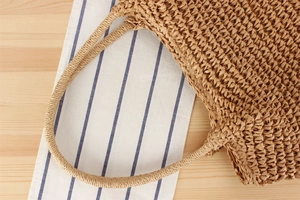 Close-up of thick round woven handles on a natural handmade paper rope tote bag