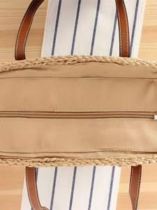 Top view of French woven tote bag with brown leather handles and secure zip closure