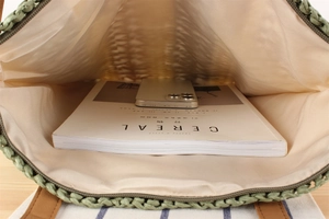 Detail of green woven paper rope tote bag with large capacity and inner lining zipper