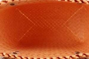 Detail view of the spacious interior and woven texture of the bright orange tote bag