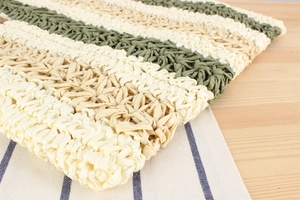 Detailed view of honeycomb paper rope weave pattern in cream, green and khaki stripes