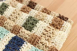 Detail of multi-color striped hollow paper rope crochet weave with a natural texture