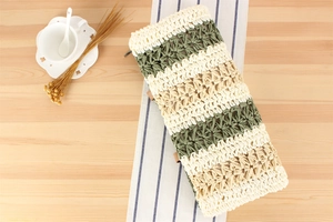 Macro detail of paper rope woven bag with olive green stripes and zipper closure