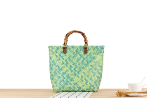 Detail of woven straw bag with bamboo handle and premium brown leather connectors