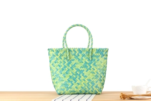 Detail of handwoven tote bag featuring green and blue geometric herringbone pattern