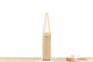 Detail of beige hand-woven crochet mesh tote bag featuring a square openwork pattern