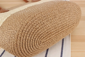Macro detail of handwoven straw tote bag base and striped texture with leather handle