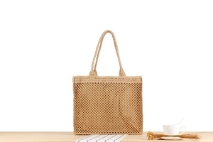 Detailed close-up of natural woven straw tote bag texture and reinforced handles