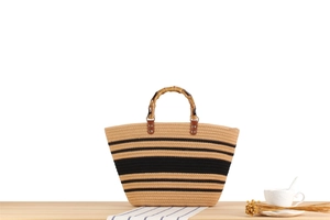 Dettaglio della borsa tote tessuta a righe con manici in stile bambù e trama elegante