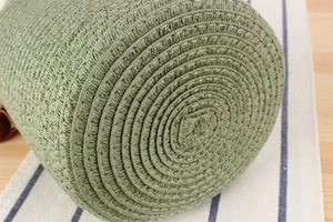 Detailed close-up showing the tight paper rope weave and spiral base of the green tote bag