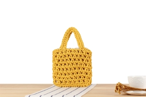 Detailed view of yellow hand-woven crochet tote bag with textured mesh and inner lining