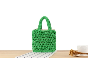 Detail of green handmade woven tote bag with cotton rope texture and cream fabric lining