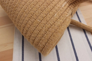 Detailed close-up showing the natural jute fiber texture and spiral stitching of the woven bag