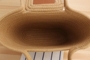 Detailed interior of large woven straw bag with brown leather trim and natural texture