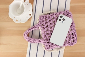 Detail view of purple hand-woven bag with hollow design and white drawstring lining