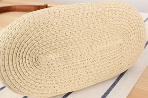Detailed view of handwoven straw tote base with meticulous oval stitching and natural texture