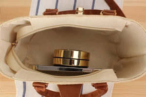 Interior view of straw woven tote bag showing white lining and zipper pocket