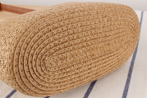 Detail of paper rope woven bag base with reinforced white stitching and leather strap