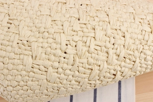 Close-up of ivory woven tote bag showing detailed texture and handmade straw craftsmanship