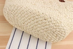 Close-up detail of beige woven straw tote bag texture for summer beach vacation