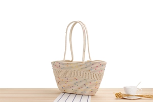Détail du sac cabas en corde de coton avec pompons colorés et motifs de vagues tissés