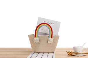 Detail of handmade cotton rope rainbow bag handle on minimalist woven beach tote bag