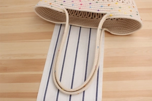 Gros plan détaillé du sac de plage en corde de coton beige avec petits pois colorés brodés