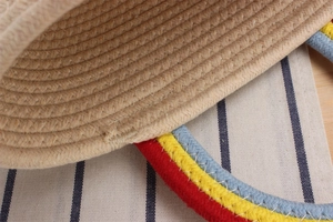 Detail of colorful woven cotton rope handle on a rainbow handmade beach straw bag