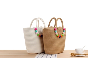 Détail de sacs fourre-tout en coton tissé à la main avec des pompons en peluche colorés