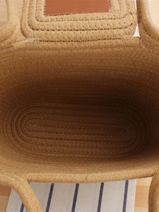 Large woven tote bag for beach vacations featuring natural textures and brown leather trim