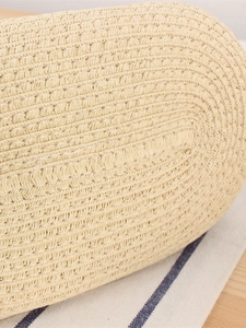 Bottom view of woven straw beach bag showing spiral pattern and natural fiber texture