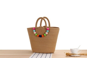 Détail du sac cabas en corde de coton tissé à la main avec pompons multicolores