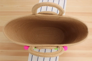 Vue de dessus du sac tissé en corde de coton avec pompons colorés et anses rondes
