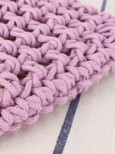 Handcrafted purple woven bag with hollow geometric texture on beige linen background