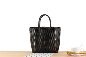Détail du tissage fait main noir et doré sur un grand sac cabas de plage pour femme