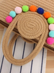 Sac fourre-tout en corde de coton tressé avec pompons colorés sur fond rayé bleu