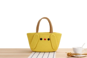 Detail of yellow woven cotton tote bag featuring cute cartoon animal face and long ears