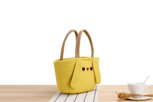 Close-up of yellow cotton woven bag with cartoon animal face and brown rope handles